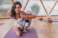 Smiling Woman Stretching On Yoga Mats In Class