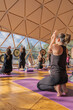 © ADDICTIVE STOCK - People doing yoga on yoga mats in domed hall