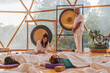 © ADDICTIVE STOCK - People in white robes hitting gong in bright room