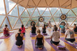 © ADDICTIVE STOCK - People doing yoga on yoga mats in domed hall