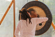 © ADDICTIVE STOCK - Spiritual woman hitting gong while calm people lying on yoga mats with eyes closed in yoga class