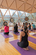 © ADDICTIVE STOCK - People doing yoga on yoga mats in domed hall