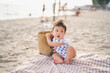 baby in white dress on the beach with relaxing and the wind blows in evening time and sit on canvas