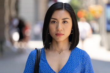 Young Asian woman in city serious face portrait