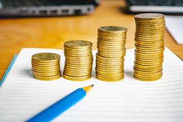 Saving money as a concept. Vintage retro stack of gold coins on the wooden background to represent It's time to do investing for retirement planning.