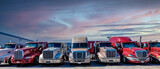 Semi trucks lined up on a parking lot at logistics warehouse