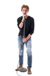 © sharplaninac - Cool young handsome male rock music singer singing on microphone looking at camera. Full body length isolated on white background.