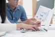 © successphoto - Asian business people meeting new startup project pointing graph discussion and analysis data charts and graphs.Business finances and accounting concept