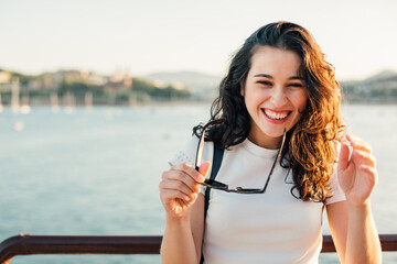 Wall Mural - Portrait of a laughing girl by the sea at sunset