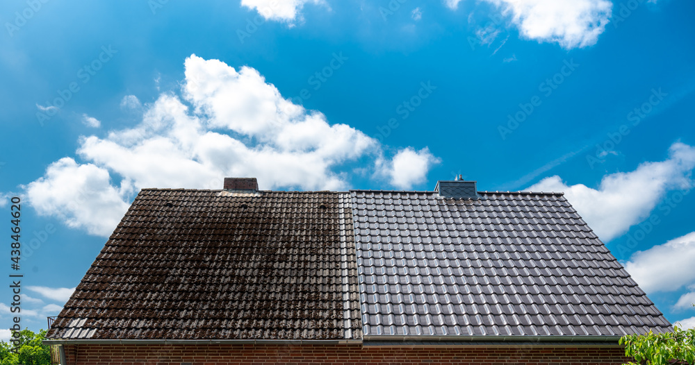 A half cleaned house roof shows the before and after effect of a roof cleaning. - obrazy, fototapety, plakaty 