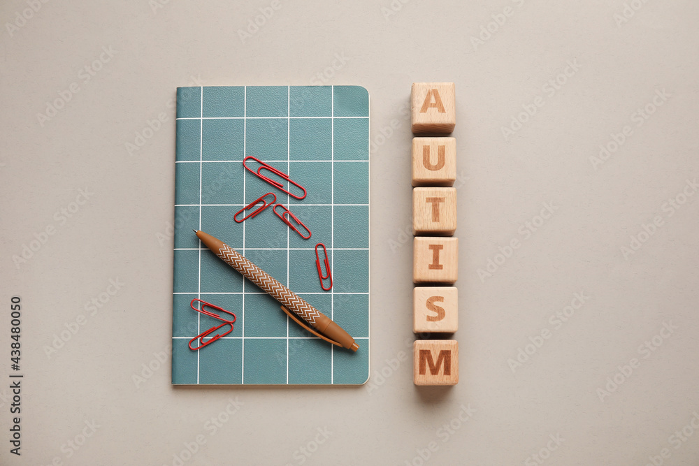 Notebook with word AUTISM and pen on light background