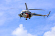 Helikopter policyjny w akcji poszukiwawczej na niebie.
