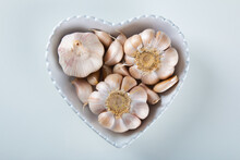 Garlic Cloves And Bulb In Heart Bowl With White Background