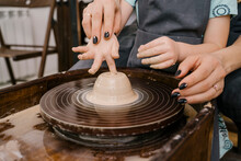 Woman Helping Girl To Mold Mass In Pottery Wheel
