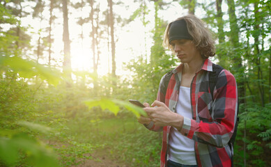 Man with smartphone lost in the forest.