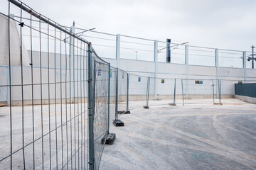 Valencia, Spain - June 9, 2021: Temporary walls and metal fences separate a new industrial construction zone.