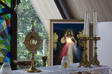 Catholic Eucharistic adoration chapel with Divine Mercy picture of Jesus Christ, candles and holy bread of life - the Blessed Sacrament on the altar.