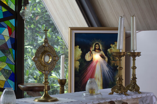 Wall Mural -  - Catholic Eucharistic adoration chapel with Divine Mercy picture of Jesus Christ, candles and holy bread of life - the Blessed Sacrament on the altar.