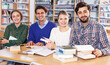 © JackF - Friendly group of students preparing together for exam in modern university library .
