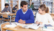 © JackF - Portrait of smiling female and male students working in university library ..