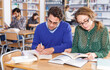 © JackF - Portrait of smiling female and male students working in university library ..