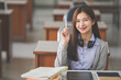 © EduLife Photos - Stock photo of a young teenage woman Asian college student in student uniform studying and writing on a notebook in a university classroom