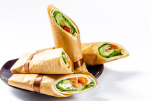 White Isolated Background, Plate, Shawarma Rolls In Paprika Paper, Cut Into 2 Parts, With Red Fish And Salad Greens, With Baked Vegetables