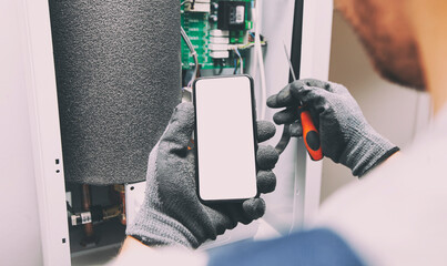 The electrician showing the phone with blank screen. Mockup for house repair or building