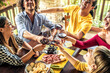 © Davide Angelini - Happy adult friends dining drinking red wine on terrace rooftop home party - Multiracial young people at lunch having fun eating bbq food in gastronomic rustic restaurant - Friendship, youth concept