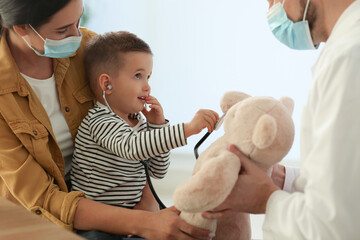 Canvas Print - Mother and son visiting pediatrician in hospital. Doctor playing with little boy