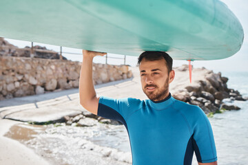 Man carrying paddle board on head