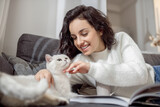 Fototapeta Koty - Female pet owner looking happy while spending time with her cat