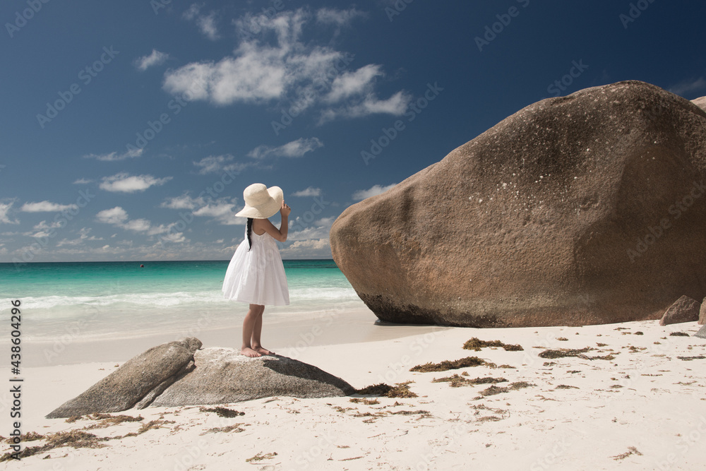 Young girl in white dress and wide hat on tropical beach of Indian ...