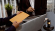 © ArLawKa - Businessmen are offering money to lawyers consulting in office with judge hammer and judge scale with laptop lawyer concept and legal advisor.