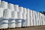 Fototapeta Sypialnia - Group of white big bags with chemical fertilizers in a warehouse outdoors.