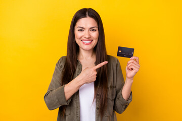 Sticker - Photo of charming cheerful young woman point finger credit card pay money sale isolated on yellow color background