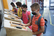 © Wavebreak Media - Group of diverse students wearing face masks using digital tablets at school