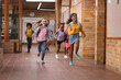 © Wavebreak Media - Group of diverse students running together in the corridor at school