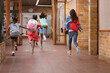 © Wavebreak Media - Rear view of group of girls running in the corridor at school