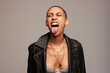 Woman with shaved head sticking out her tongue