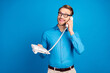 Photo of young man happy positive smile call talk speak conversation phone look empty space isolated over blue color background