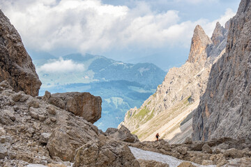 Wall Mural - Rocky mountain canyon with a scenic view to a valley in the alps with a mountain wanderer