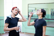 Young Boy And Girl Dancers Drink Water And Relax After Having A Training. Professional Ballet, Regular Practice, Hydration Concept.