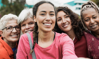 Wall Mural - Multiracial women smiling in camera while taking a selfie at park after yoga class - Multi generational people concept