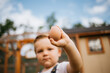 Toddler holding fresh chicken egg in front of coop