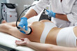 Ultrasound cavitation body contouring treatment. Woman getting anti-cellulite and anti-fat therapy in beauty salon