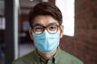 © wavebreak3 - Portrait of asian businessman wearing face mask in office looking to camera
