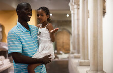 African American Man And His Little Daughter Looking At Exhibits Of Antique Sculpture At Historical Museum