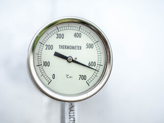 Temperature gauge for measuring instrument close up in industry zone at power plant.