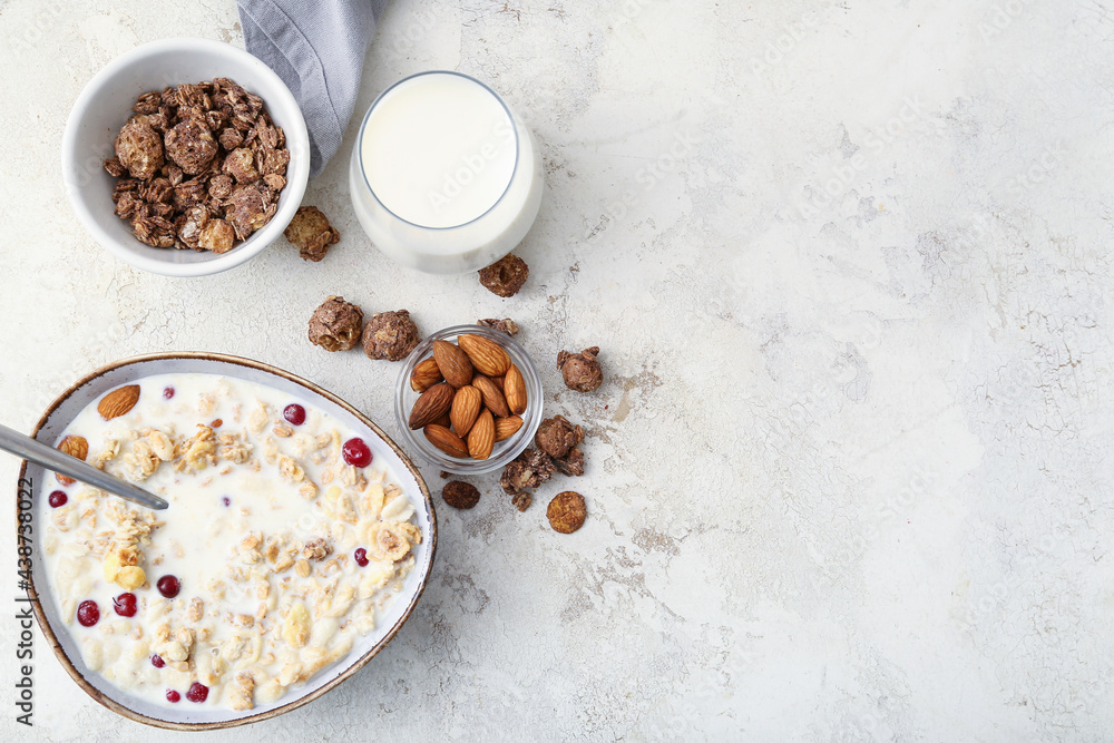 Tasty granola with milk on light background
